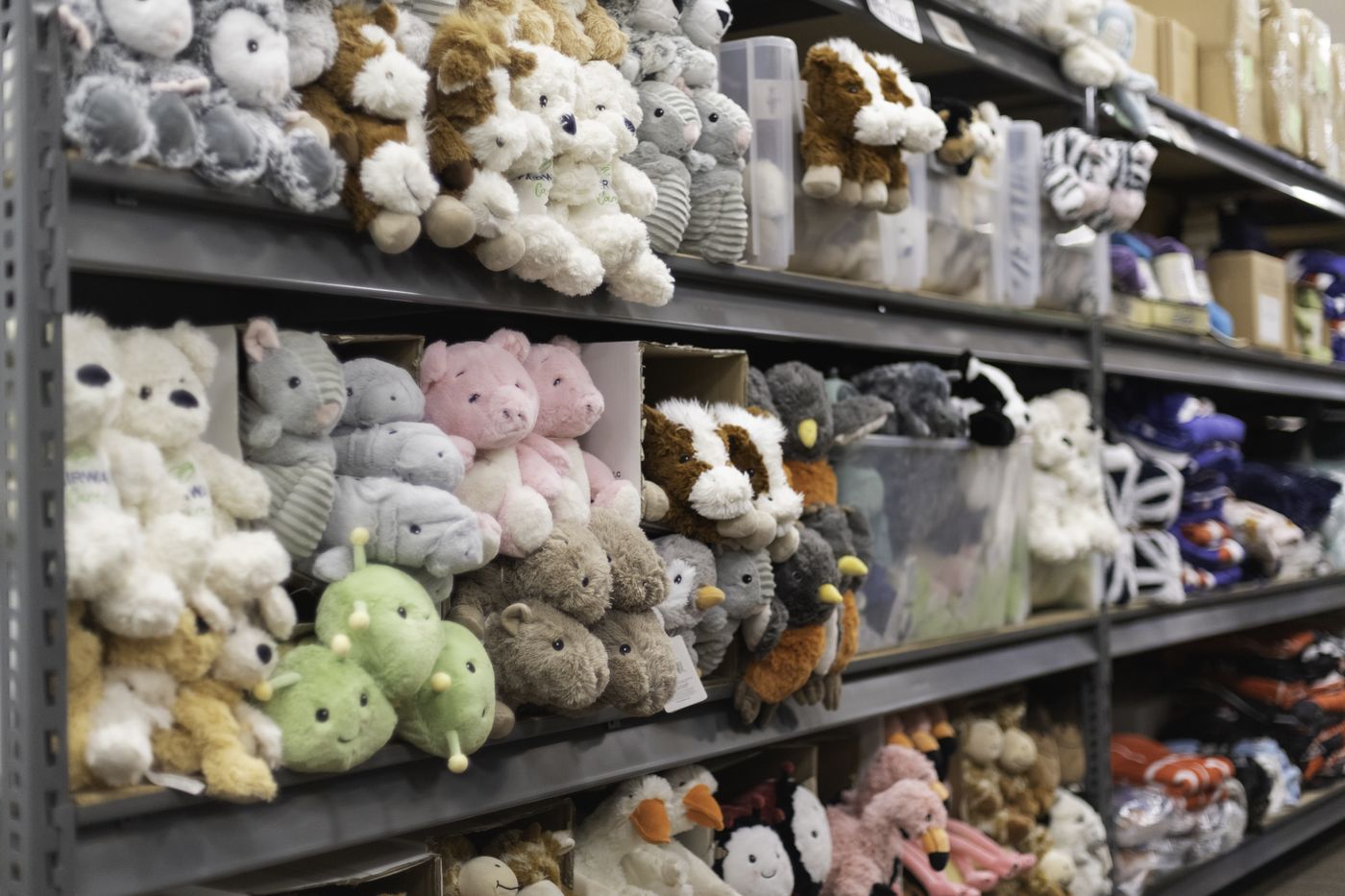 Warehouse shelves stocked floor to ceiling with plush comfort animals